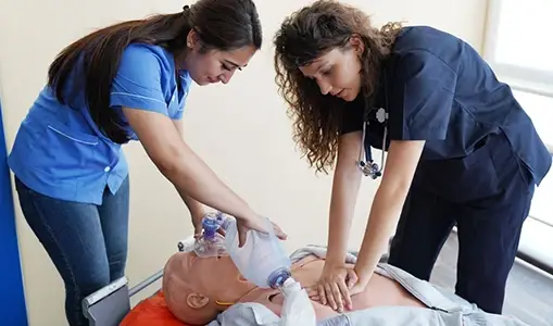 Two Medical Professionals Performing CPR on a Mannequin in a Training Session