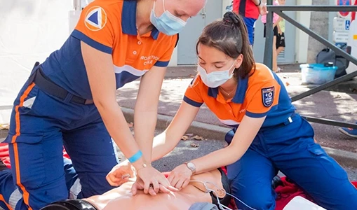 Two People Performing CPR Training on Dummy Outside