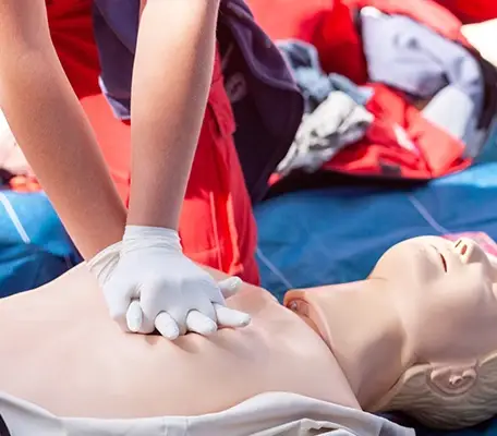 CPR Training Session with Instructor Practicing Chest Compressions on Dummy